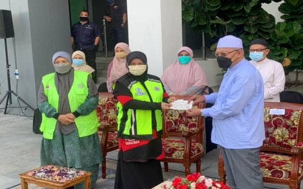 Ahmad (kanan) menyerahkan cek sumbangan kepada Exco Kerajaan Negeri, Datuk Mumtaz Md Nawi untuk disampaikan kepada kerajaan Pahang.