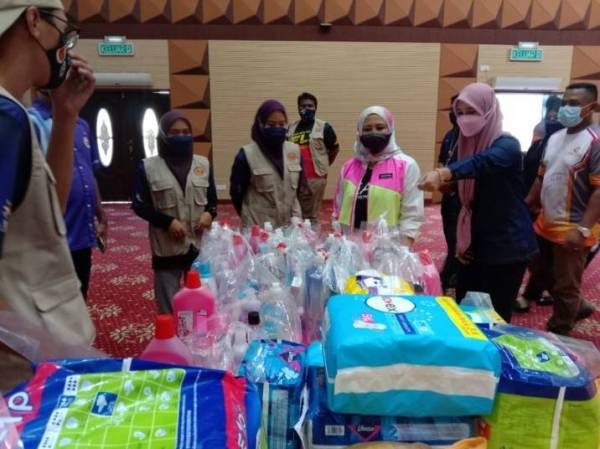 Wasitah (tiga kanan) ketika meninjau pusat agihan barangan bantuan banjir di Kombes pada Jumaat.