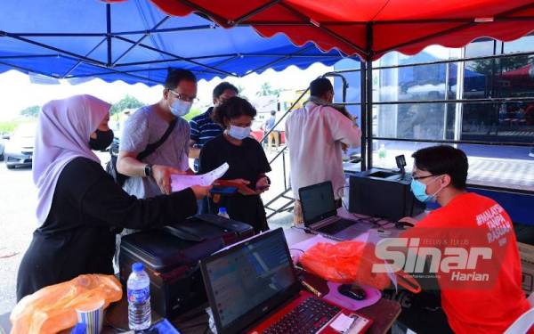 Misi #BantuanBencana Sinar Harian x Rasuah Busters membuka kaunter untuk mencetak gambar dan mengimbas dokumen sokongan bagi membantu mangsa banjir di pekarangan Surau Nurul Iman, Kampung Lombong, Seksyen 2, Shah Alam, pada Jumaat. - Foto Sinar Harian MOHD HALIM ABDUL WAHID.