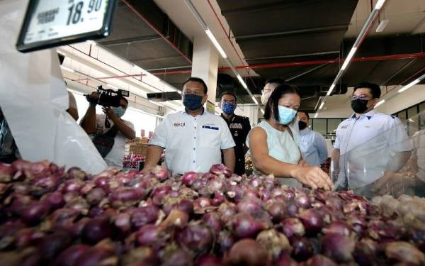 Alexander (tengah) membuat tinjauan harga barang di sebuah pasar raya di Kuching pada Jumaat. - Foto Bernama