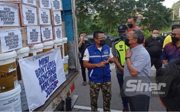 Hasni (kanan) meninjau barangan keperluan yang akan dihantar menerusi Misi Bantuan Banjir Pemuda UMNO Johor dan Rakyat Johor di Pejabat Perhubungan UMNO Negeri Johor pada Sabtu.