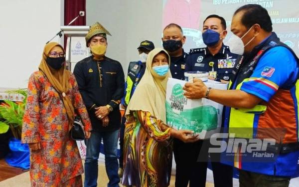 Muhamad Zaki (dua dari kanan) menyampaikan sumbangan ketika Majlis Sumbangan Kotak Rezeki Kelab Motosikal Berkuasa Tinggi (G20 Goldwing Malaysia) bersama IPD Pasir Mas dengan kerjasama Mapim di Pasir Mas pada Jumaat.
