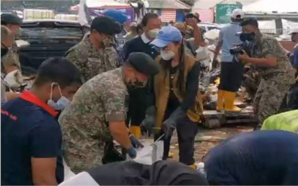  Michell meluangkan masa cuti perayaan Krismas dengan menyertai kerja-kerja pembersihan pasca banjir di Taman Sri Muda, Shah Alam, pada Sabtu. - Foto Astro AWANI 