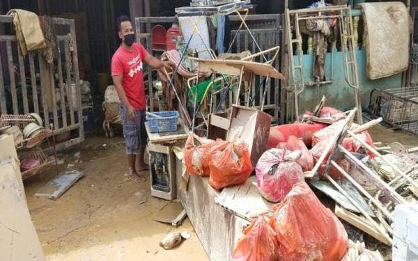 Mohd Jefri menunjukkan longgokkan barang yang terpaksa dibuang akibat banjir.