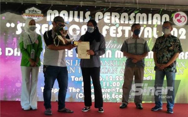 Nolee Ashilin (dua dari kanan) menyampaikan hadiah kepada pemenang pertandingan Festival Kucing Jalanan 2021 di Cengkerik Eco Park, The Treasure @ Taman Herba pada Ahad.