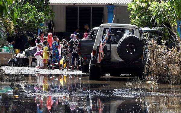 Penduduk kampung yang menjadi mangsa banjir memilih baju baru yang disumbangkan oleh sukarelawan ketika tinjauan di Kampung Labohan Dagang Kuala Langat Banting.- Foto Bernama