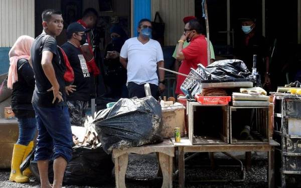 Abdul Latif (dua dari kanan) menyantuni mangsa banjir di Kampung Labohan Dagang Kuala Langat Banting pada Ahad. - Foto Bernama