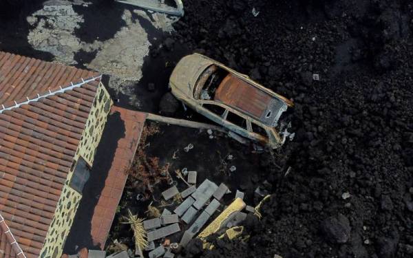 Lahar dimuntahkan Cumbre Vieja memusnahkan kenderaan dan kediaman penduduk di La Palma. - Foto AFP