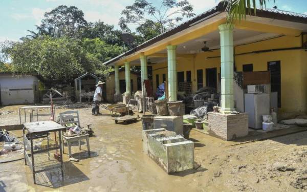 Ja’apar melakukan kerja-kerja pembersihan setelah rumah inap desanya mengalami kerosakan melibatkan barangan perabot, kenderaan dan barang elektrik, selain 80 ekor ayam kampung miliknya turut hilang. - Foto Bernama