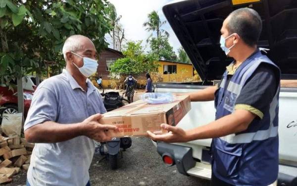 Ali Akbar (kanan) menyerahkan sumbangan dapur gas kepada penerima Sabtu lalu.