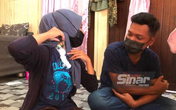 Siti Nuramziah Ramli, 24, (kiri) menunjukkan kesan tebuk pada leher bagi rawatan hemodialisis yang dijalankan kerana penyakit buah pinggang yang dihidapi.