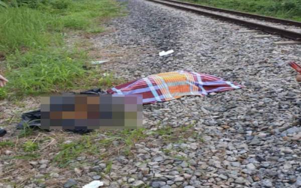 Mayat mangsa yang terbaring di landasan kereta api di Kampung Tiong, Gua Musang pada Isnin.