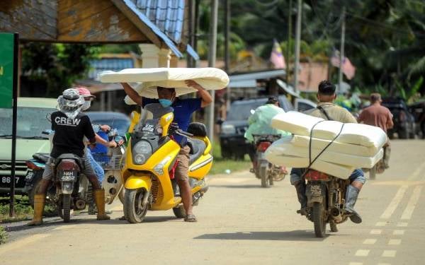 Gelagat penduduk Kampung Cennah membawa pulang tilam dan bantal yang disumbangkan kepada mangsa banjir di Kampung Cennah pada Program Prihatin Menteri Komunikasi dan Multimedia bersama mangsa banjir Jelebu di Balai Raya Kampung Cennah. - Foto Bernama