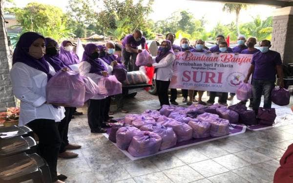 Nor Azizah (lapan, kiri) bersama para sukarelawan memungah bungkusan makanan ke dalam kenderaan dan akan diagihkan kepada mangsa banjir di Mentakab, Pahang. - FOTO SINAR HARIAN