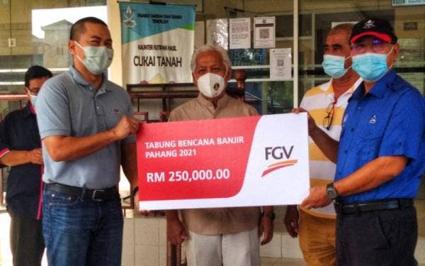 Mohd Nazrul Izam (kiri) menyerahkan replika cek kepada Wan Rosdy (kanan) sambil diperhatikan oleh Idris (tengah) di pekarangan Pejabat Daerah dan Tanah Temerloh pada Rabu.