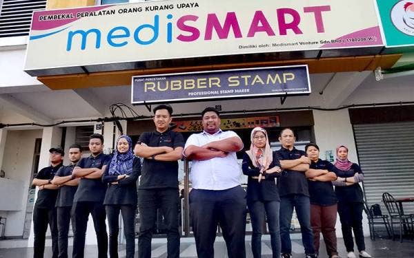 Mohd Firdaus (lima dari kanan) bersama pekerjanya di Seremban.