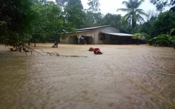 Anggota bomba melakukan operasi menyelamat mangsa yang terperangkap Kampung Baru, Jalan Malaysia di Jeli pada pagi Khamis. - Foto ihsan JBPM
