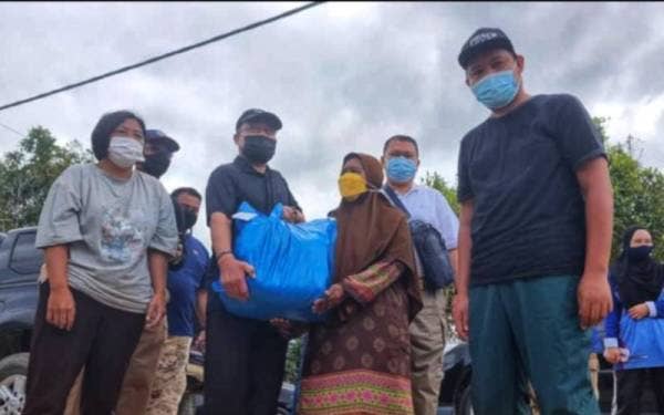 Hasagaya (dua dari kiri) menyampaikan sumbangan kepada ibu wartawan Sinar Harian, Yazi Samat (tiga dari kiri) dalam satu kunjungan ke kediaman tersebut di Kampung Batu Kapor, Mentakab pada Rabu.