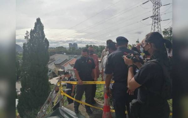 Amirudin (kiri) meninjau keadaan tebing runtuh di Apartmen Teratai, Selayang pada Khamis.