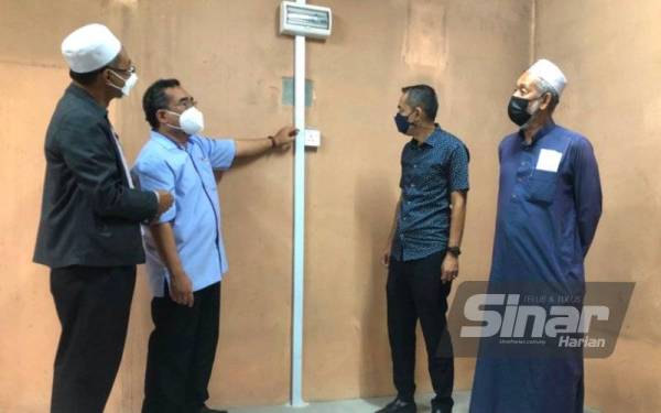Pengarah Jabatan Penguatkuasaan dan Operasi Kawasan ST, Mohd Elmi Anas (dua, kiri) dan Ahli Dewan Undangan Negeri (ADUN) Bunut Payong, Datuk Dr Ramli Mamat (kiri) melihat kesan bekas terbakar di Maahad Tahfiz Al-Quran Al-Ridha, Kota Bharu, pada Khamis.
