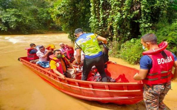 Pasukan Bomba dan Penyelamat Kuala Krai bertindak di luar kebiasaan dalam membantu operasi banjir dengan mengusung dan membawa jenazah keluar selepas jambatan ditenggelami air di Kampung Sungai Pas, Kuala Krai pada Jumaat.