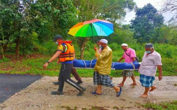 Proses membawa jenazah keluar turut dibantu anggota PDRM. 