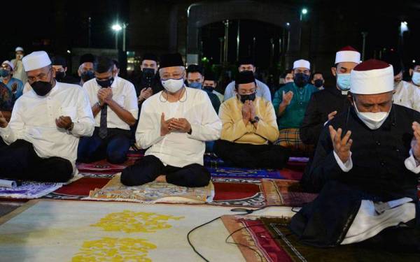 Ismail Sabri (dua, kiri) mengaminkan doa yang dibaca oleh Imam Besar Masjid Putra, Salahuddin Ghozali pada Program Solat Hajat dan Munajat Perdana Bagi Mendoakan Kesejahteraan Malaysia sempena Tahun Baharu 2022 di Masjid Putra malam ini. - Foto Bernama