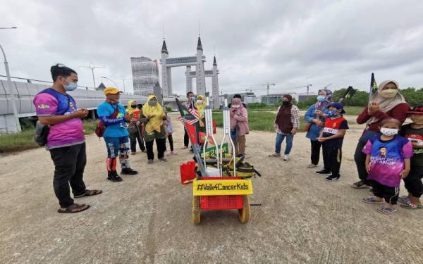 Mukhlis (dua dari kiri) membaca doa sebaik tiba di destinasi terakhir di Kuala Terengganu ketika menamatkan misi berjalan kaki sempena kempen #Walk4CancerKids pada Jumaat.