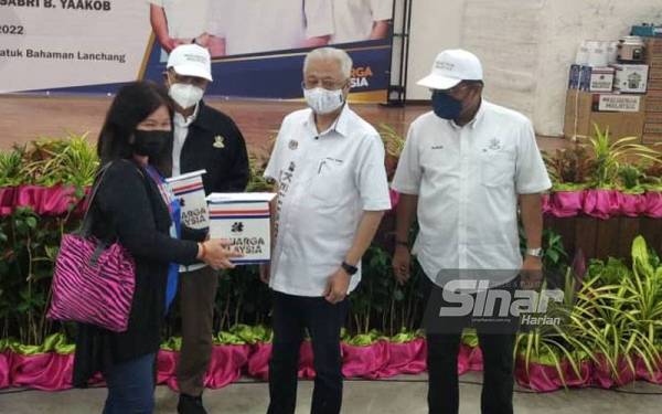 Ismail Sabri (tengah) menyerahkan bantuan kepada mangsa banjir di Dewan MPT dekat Lanchang pada Sabtu.