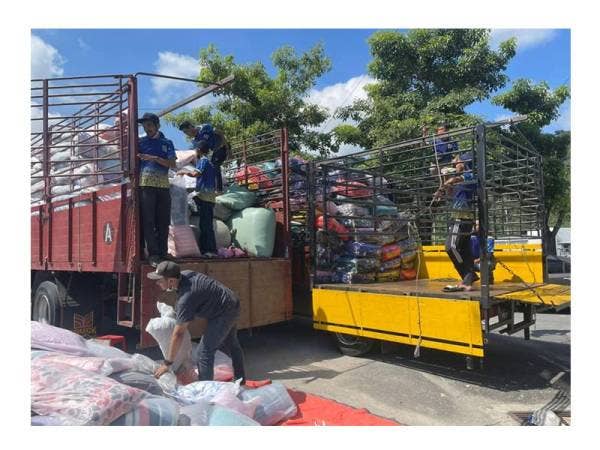 Para sukarelawan menurunkan barangan bantuan daripada lori-lori yang tiba dari Perlis.