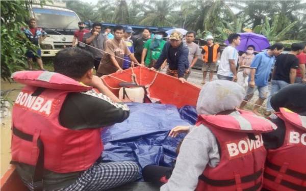 Sepasukan anggota bomba menaiki bot membawa jenazah keluar dari Kampung Rumidi Batu 8 Sapinangoh, untuk diserahkan kepada polis.