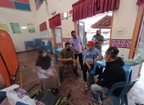Mejar Mohd Shazwan (duduk dua kiri) ketika melawat PPS di SMK Gemas, Tampin pada Ahad. 