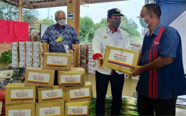 Annuar (kiri) menyaksikan agihan sumbangan yang dibuat oleh Pengarah Jabatan Penerangan (JaPen) Kelantan, Azahar Ismail (dua dari kanan) kepada penerima
pada Majlis Penyerahan Kotak Kasih KKMM Dan Bantuan Rumah Prihatin di Dewan Tun Abdul Ghaffar Baba, Yayasan Kemisiknan Kelantan (YKK) di Melor, Kota Bharu pada Ahad.