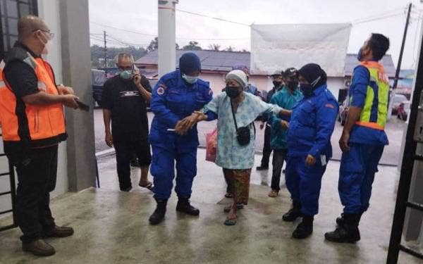 Anggota Angkatan Pertahanan Awam (APM) membantu memindahkan warga emas ke PPS Dewan Raya Sungai Tiram, Johor Bahru pada malam Ahad.