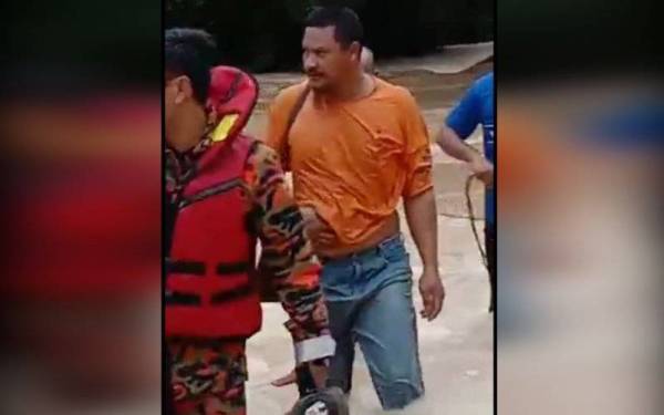 Nor Ibrahim (tengah) berjaya diselamatkan pihak bomba selepas hanyut dibawa arus banjir dalam kejadian di Bukit Sengit Pogoh, Segamat, pada Isnin.