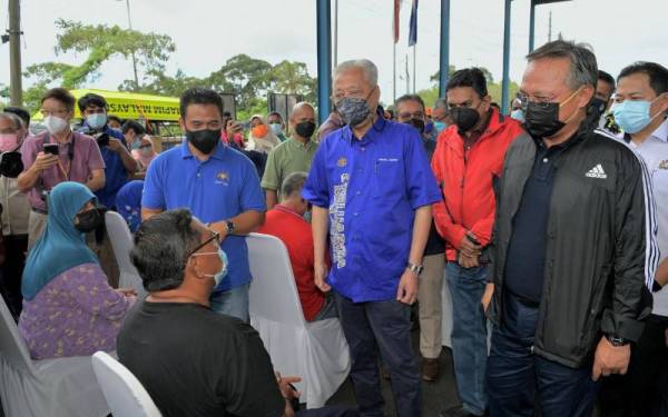 Ismail Sabri (empat dari kanan) beramah mesra dengan mangsa-mangsa banjir yang ditempatkan di PPS di Dewan Kampung Tandong hari ini.