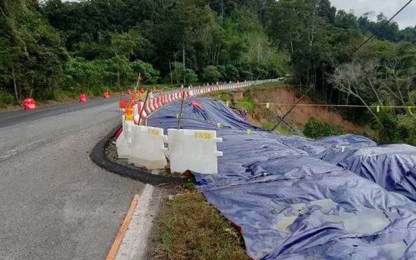 Pengguna jalan raya diminta berhati-hati apabila melalui Jalan Kupang-Gerik-Jeli Jalan Raya Timur Barat (JRTB) selepas Pusat Perikanan Banding yang retak dan mendap akibat tanah runtuh sejak 19 Disember lepas. - Foto JKR Perak