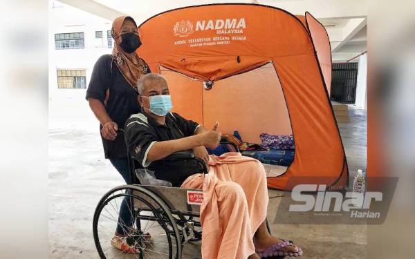 Siti Hasnah bersama suaminya yang lumpuh sebelah badan ketika ditemui di PPS SK Taman Merdeka di sini, pada Rabu.