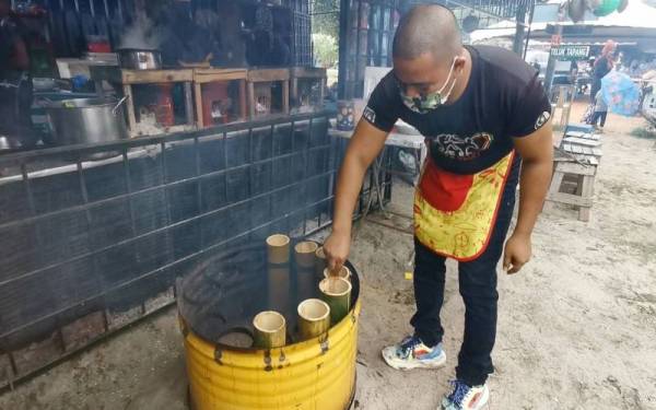 Ahmad Faizul menyiapkan hidangan mi segera yang dimasak di dalam buluh ditempah pelanggan di premis perniagaannya di Kampung Tok Jembal di Kuala Nerus.