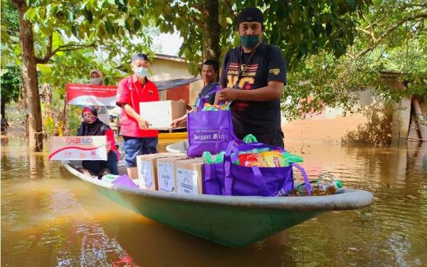 Mohd Sakeri (dua dari kanan) menerima sumbangan yang disampaikan oleh Mohamed Afandi (kiri) daripada POKB di Kampung Tersang, Rantau Panjang pada Rabu.