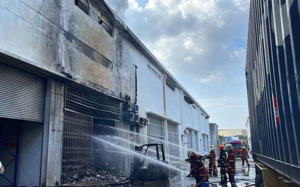 Anggota bomba sedang memadamkan kebakaran di sebuah kilang pemetik api di Seksyen 22, Shah Alam pada Rabu.
