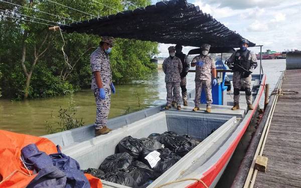 Mohd Zawawi (dua dari kanan) menunjukkan tempat daun ketum disembunyikan di dalam bot untuk diseludup ke negara jiran.