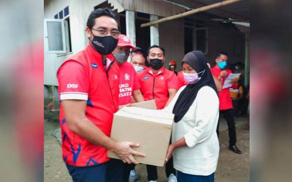 Wan Ahmad Fayhsal (kiri) menyampaikan sumbangan kepada mangsa banjir di Kampung Serongga, Rantau Panjang pada Rabu.
