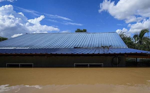 Ketinggian air yang hampir menenggelamkan sebuah rumah yang dibina setinggi 14 kaki di Kampung Seberang Batu Badak, hari ini.