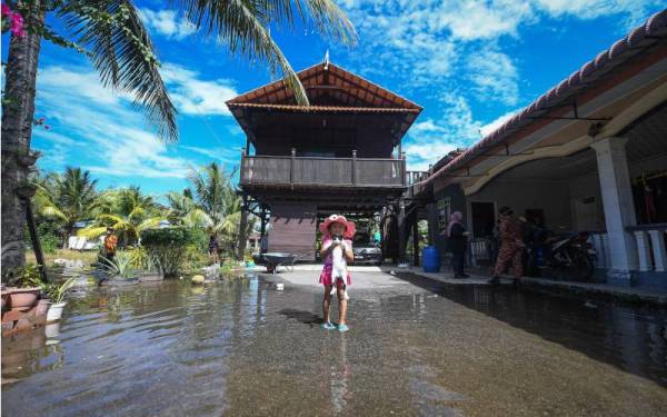 Kanak-kanak berusia empat tahun, Aifa tetap ceria bermain bersama kucingnya Jimmy walaupun kawasan sekitar rumahnya mula dinaiki air sehingga 0.5 meter ketika tinjauan Bernama. - Foto Bernama 