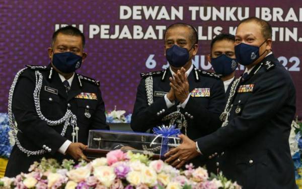 Wan Hassan (kanan) menerima tongkat kuasa Ketua Polis Kedah dari Kamarul Zaman (kiri) sambil diperhatikan Razarudin di IPK Kedah pada Khamis.