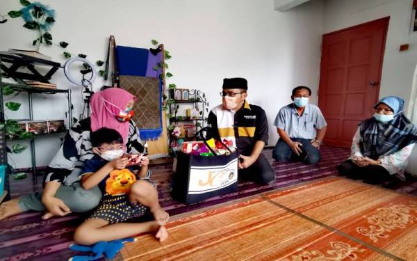 Noor Herra Hardiana menerima kunjungan Zulkifli (tiga dari kanan) di rumahnya di Flat Taman Sri Mawar, Seremban pada Rabu.