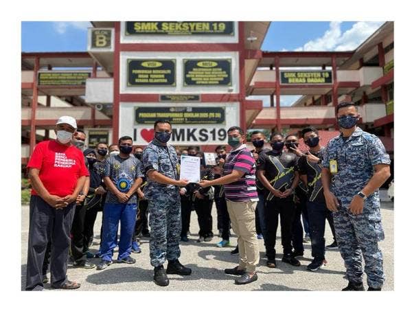 Mejar Hassan Basri dan Abdul Rahim saling bertukar cenderahati sambil disaksikan Pengurus Tugas-tugas Khas Sinar Harian, Hashim Merana Anang (kiri) selepas selesai Program Jiwa Murni, semalam.