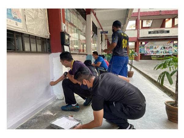 Warga No 2 Skuadron dan sukarelawan mengecat dinding sekolah selepas terkesan akibat banjir.