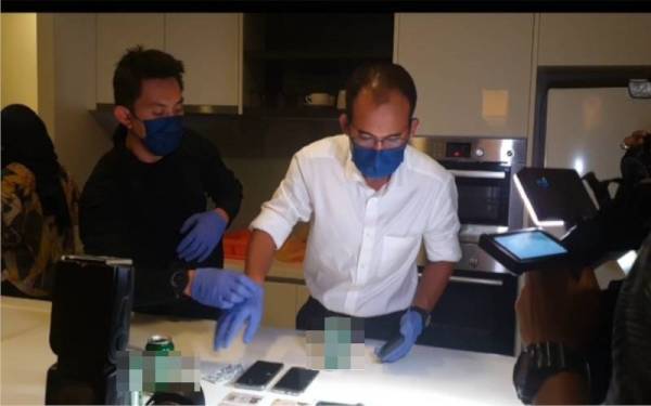 Khairul Dzaimee memeriksa dokumen perjalanan wanita warga Afrika yang ditahan dalam serbuan pada Khamis.